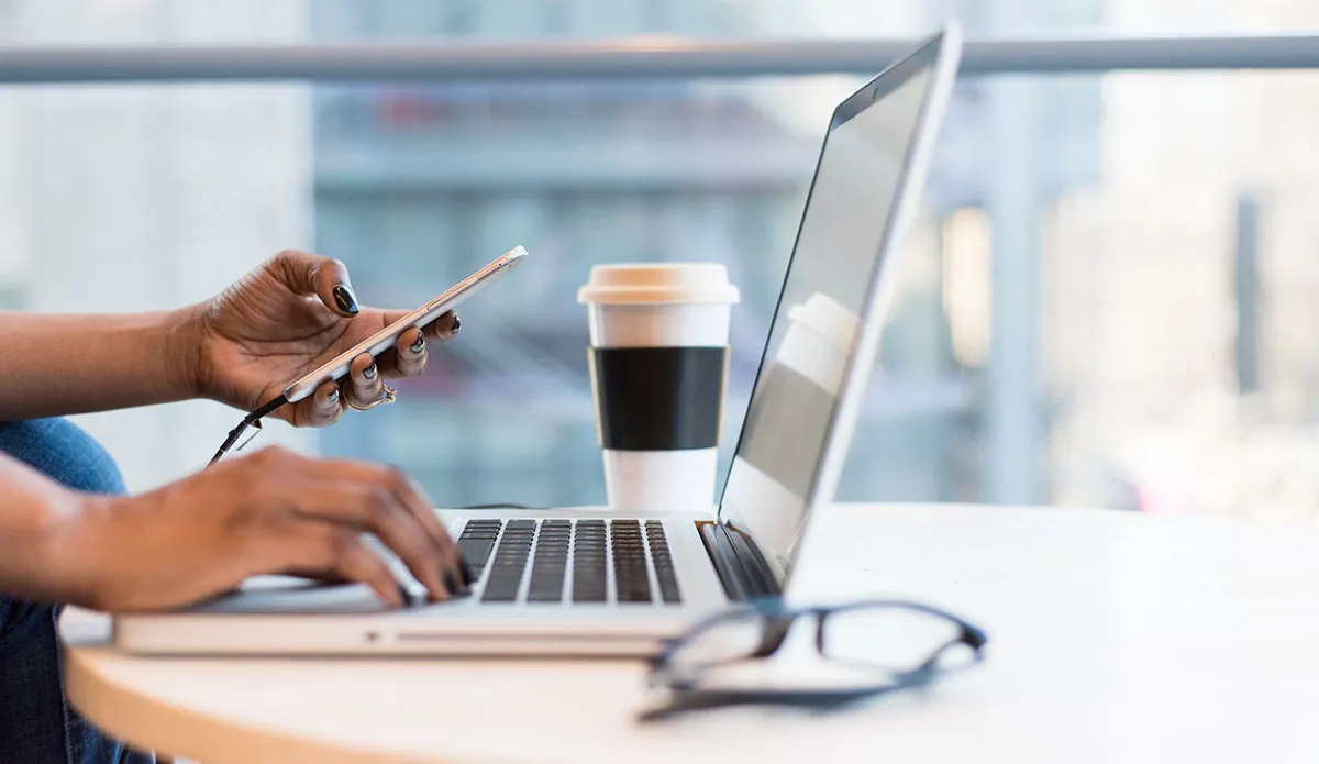 person on phone and laptop