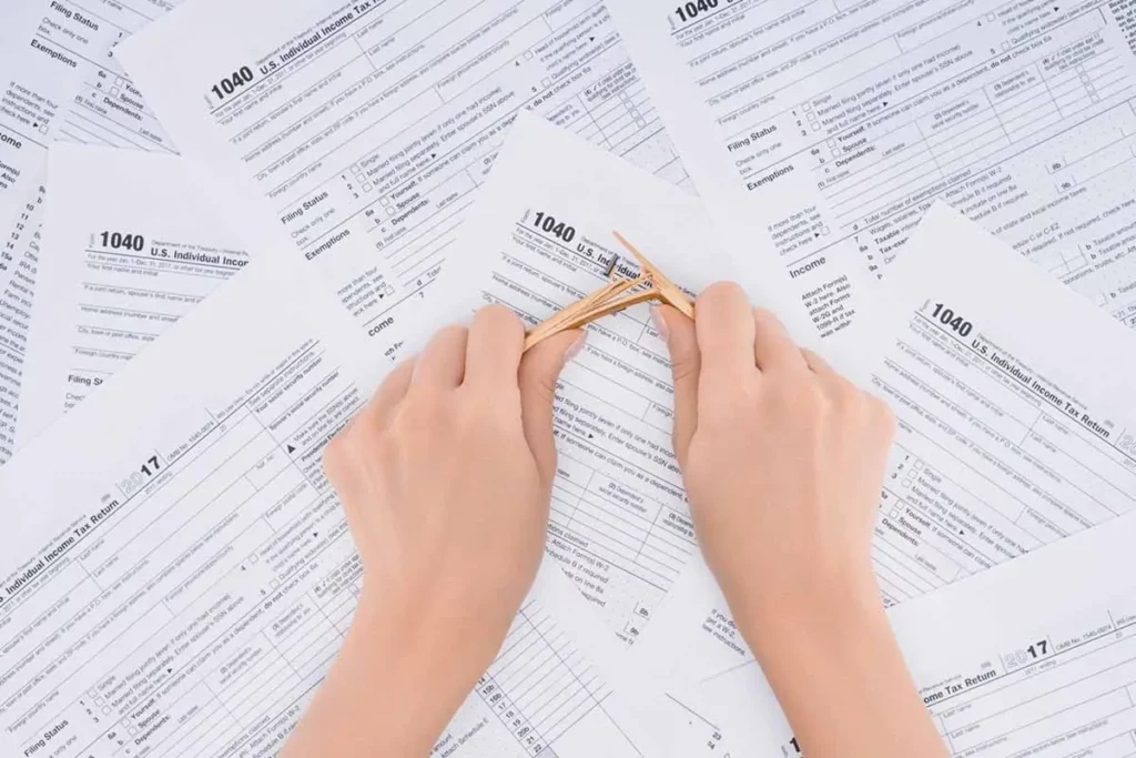 Woman breaking pencil on top of IRS paperwork